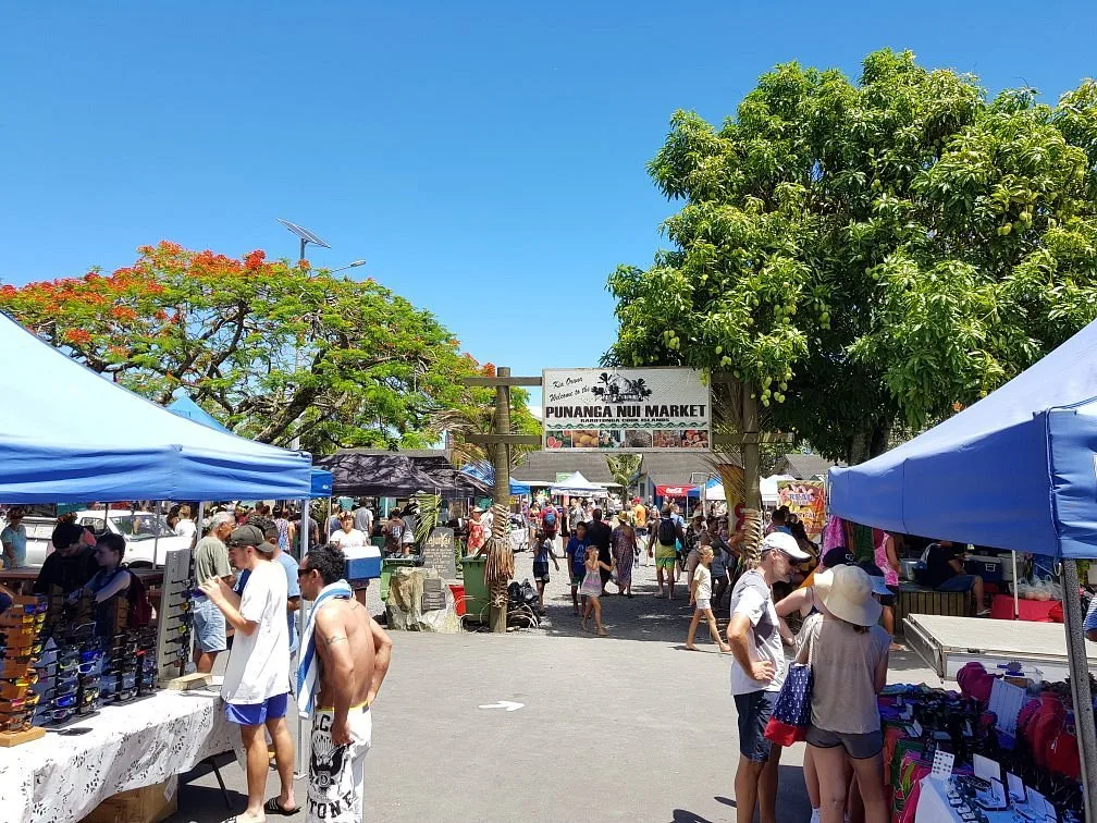 Vibrant scene at Punanga Nui Market, where locals and visitors mingle over fresh produce and crafts.